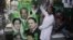 Pakistani vendors fix posters of candidates taking part in the upcoming parliamentary elections in Lahore, Pakistan, April 5, 2013.