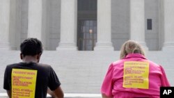 FILE: People wait outside of the U.S. Supreme Court building on Thursday, June 29, 2023, on Capitol Hill in Washington. The Supreme Court ruled 6-3 on June 30, 2023 that the Biden administration overstepped its authority in trying to cancel or reduce student loans.