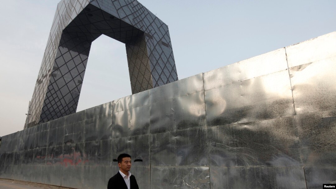 Seorang pria berjalan di luar bangunan stasiun Televisi Pemerintah China (CCTV), Beijing (Foto: dok).