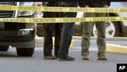 A gun lies on the ground inside a police barricade following a shooting at a Kroger grocery that left two people dead and a suspect in custody in Jeffersontown, Ky., Oct. 24, 2018.