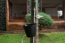 FILE - A tap with a bucket and a bar of soap is available for students to wash their hands as a preventive measure against the spread of the COVID-19 coronavirus at the Lycée Général Leclerc School in Yaounde, June 1, 2020.