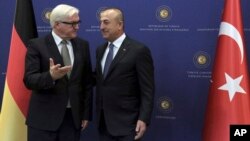 Menlu Jerman Frank-Walter Steinmeier (kiri) sebelum pembicaraan dengan Menlu Turki, Mevlut Cavusoglu di Ankara hari Selasa (15/11).