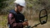 A Cambodian Mine Action Center, CMAC, staff member checks a mine detector at a minefield in Preytotoeung village, Battambang province, Cambodia, Jan. 19, 2023. 