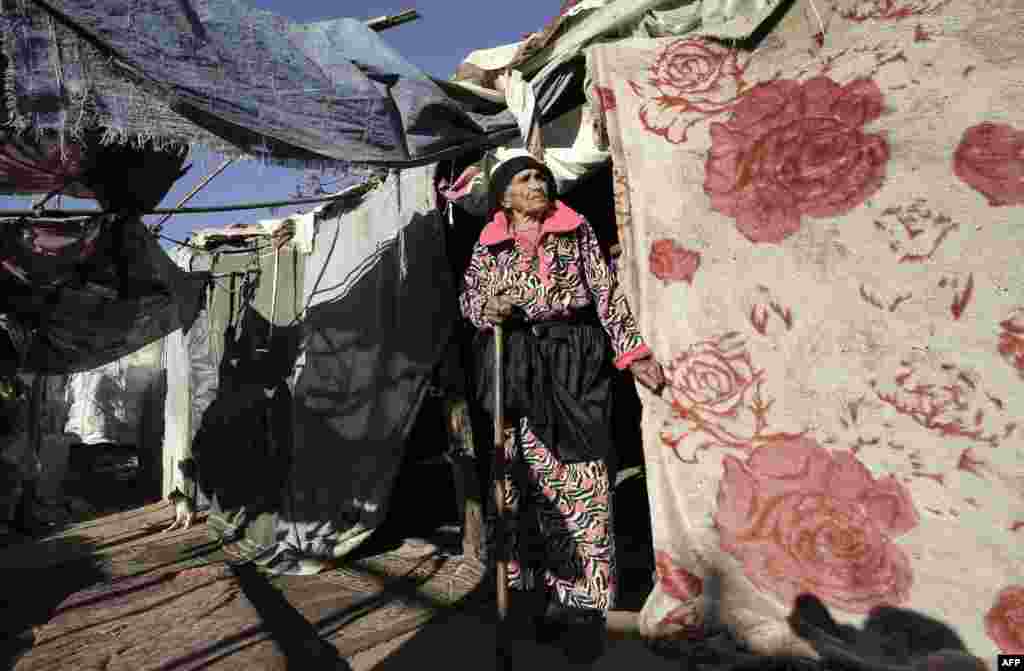 A Palestinian woman stands next to her home near the site of an Israeli airstrike the previous night in Gaza City.