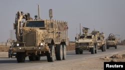 FILE - U.S. military vehicles drive in Hasaka, Syria, Dec. 6, 2024.