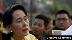 Aung San Suu Kyi (d) conversa con el general Zaw Win (i), viceministro de Asuntos Fronterizos, durante el desfile por el Día de las Fuerzas Armadas en Birmania. 