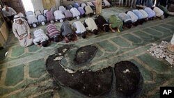 Palestinians pray inside a partially burned mosque in the West Bank village of Beit Fajjar, near Bethlehem, 04 Oct 2010