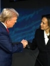 TOPSHOT - Mgombea Urais Kamala Mdemokrat Kamala Harris (kulia) akimsalimia mpinzani wake mgombea urais wa Republikan Donald Trump kabla ya kuanza Mdahalo wa Rais katika kituo chaNational Constitution Center huko Philadelphia Jumanne usiku, 