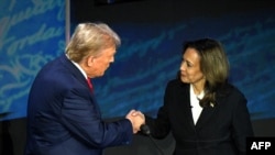 TOPSHOT - Mgombea Urais Kamala Mdemokrat Kamala Harris (kulia) akimsalimia mpinzani wake mgombea urais wa Republikan Donald Trump kabla ya kuanza Mdahalo wa Rais katika kituo chaNational Constitution Center huko Philadelphia Jumanne usiku, 