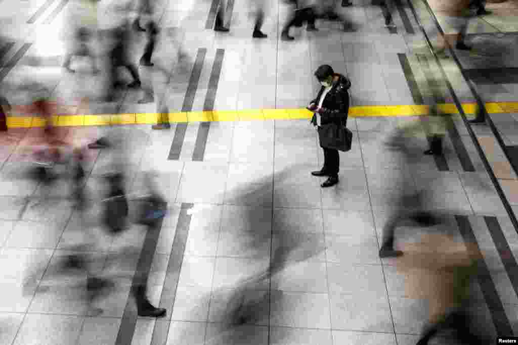 A man wearing a face mask to protect against an outbreak of the coronavirus stands at the Shinagawa station in Tokyo, Japan.