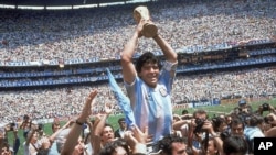 In this June 29, 1986 file photo, Diego Maradona holds up his team's trophy after Argentina's 3-2 victory over West Germany at the World Cup final soccer match at Atzeca Stadium in Mexico City. (AP)