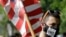 A man carries an American flag while attending a protest against police brutality, June 4, 2020, in Taunton, Mass.