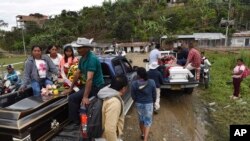 FILE - People transport the coffins of two indigenous people killed in Tacueyo, southwest Colombia, Oct. 31, 2019.