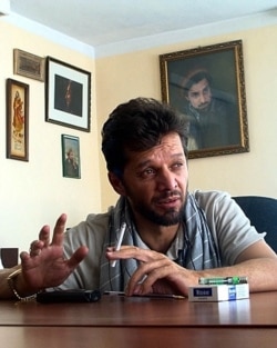 FILE - Afghan journalist Fahim Dashty speaks at his office in Kabul in this undated photograph. (Photo by STR/AFP)