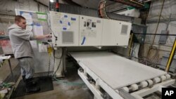 A worker begins production of a kitchen countertop that is being cut from imported quartz slabs from China in the production facility at Marble Uniques in Tipton, Ind., Friday, May 3, 2019. 