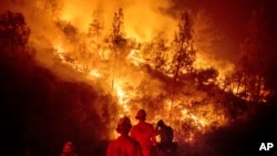 FILE - Firefighters monitor a backfire while battling the Ranch Fire, part of the Mendocino Complex Fire near Ladoga, Calif., Aug. 7, 2018.