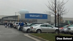 FILE - Shoppers walk in the parking lot of a Walmart store in Fairfax, Virginia. (Photo: Diaa Bekheet) Walmart says it will stop selling amunitions for handguns and assault-style weapons.