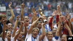FILE - In this July 5, 2015, file photo, the United States Women's National Team celebrates with the trophy after they beat Japan 5-2 in the FIFA Women's World Cup soccer championship in Vancouver, British Columbia, Canada. 