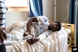 FILE - Ugandan LGBTQ+ activist Steven Kabuye receives treatment at a hospital after he was attacked by unknown people, in Kitende on the outskirts of Kampala, Uganda, January 4, 2024.