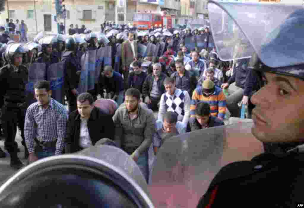 Egyptian riot police surround praying protestors in Suez, Egypt, Thursday, Jan.27, 2011. Egyptian activists protested for a third day as social networking sites called for a mass rally in the capital Cairo after Friday prayers, keeping up the momentum of 