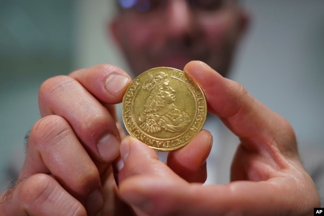 Vicken Yegparian, vice president of numismatics, Stack's Bowers Galleries, holds a golden coin once belonging to the collection of Danish king, Frederik VII, now part of L. E. Bruun's collection, in Zealand, Denmark, May 7, 2024. (AP Photo/James Brooks)