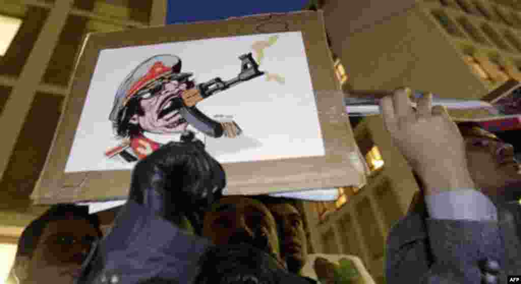 People shout slogans and hold banners during an anti-Gadhafi protest in front of the Libyan consulate in Milan, Italy, Wednesday, Feb. 23, 2011. (AP Photo/Luca Bruno)