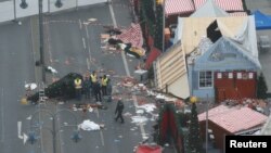 Policemen investigate the scene where a truck plowed into a crowded Christmas market in the German capital last night in Berlin, Germany, Dec. 20, 2016.