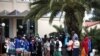 Des migrants font la queue pour recevoir des désinfectants devant un hôtel utilisé comme refuge pour réfugiés, après que les autorités ont trouvé plusieurs cas du nouveau coronavirus et mis la zone en quarantaine, à Kranidi, en Grèce, le 21 avril 2020.