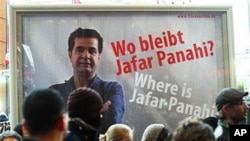 People walk in front of a poster showing Iranian filmmaker Jafar Panahi prior to the screening of the movie 'Offside' by Jajar Panahi at the International Film Festival Berlinale in Berlin, Germany, February 11, 2011