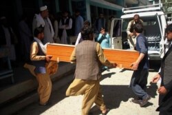 FILE - Afghans carry a coffin of the body of a woman who was killed by gunmen in the city of Jalalabad, east of Kabul. Attackers gunned down three women working to administer the anti-polio vaccine in eastern Afghanistan, officials said.