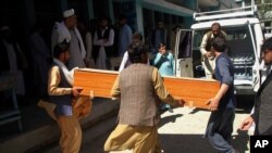 Afghans carry the body of a woman who was killed by gunmen in the city of Jalalabad, east of Kabul, Afghanistan, March 30, 2021. 