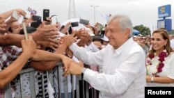 El candidato presidencial mexicano Andrés Manuel López Obrador saluda a partidarios durante un acto de campaña en Cancún, México, el martes, 26 de junio de 2018.