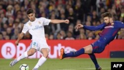 Marco Asensio rivalise avec Gerard Pique, lors du match de football entre Barcelone et le Real Madrid, Espagne, le 6 mai 2018.