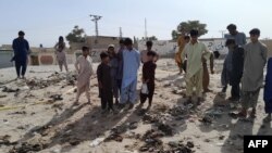 Sejumlah warga memperhatikan lokasi serangan bom bunuh diri yang menarget acara Maulid Nabi Muhammad di distrik Mastung, Provinsi Baluchistan, Pakistan, Jumat, 29 September 2023. (Foto: AFP)