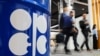 People walk past an installation depicting barrel of oil with the logo of Organization of the Petroleum Exporting Countries (OPEC) during the COP29 United Nations climate change conference in Baku, Azerbaijan November 19, 2024. 