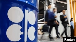 People walk past an installation depicting barrel of oil with the logo of Organization of the Petroleum Exporting Countries (OPEC) during the COP29 United Nations climate change conference in Baku, Azerbaijan November 19, 2024. 