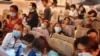 Passengers wearing masks prepare to disembark from a flight from Hong Kong on arrival at Bangkok's airport ahead of the Chinese New Year in Bangkok, Jan. 23, 2020.