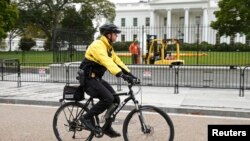 FILE - A member of the U.S. Secret Service patrols on bicycle in front of the North Lawn of the White House in Washington, Oct. 23, 2014. 