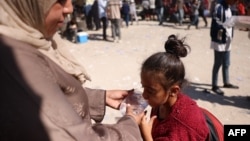 Una madre palestina ofrece agua fría a su hija de una bolsa de plástico en Khan Younis, en la zona sur de la franja de Gaza, el 21 de octubre de 2024.