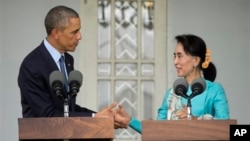 Presiden AS Barack Obama (kiri) dan pemimpin oposisi Myanmar Aung San Suu Kyi berjabatan tangan dalam konferensi pers di rumahnya di Yangon, Myanmar (14/11). (AP/Pablo Martinez Monsivais)