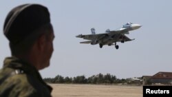 FILE - A Russian SU-33 naval fighter plane flies during a drill at the Nitka training complex in the village of Novofedorovka, west of the Crimean city of Simferopol, Aug. 27, 2015. 