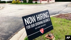 FILE - A hiring sign is displayed at Firestone Complete Auto Care store in Arlington Heights, Ill., June 30, 2021. 