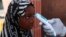 Wani Malami na amfani da na’urar auna zafin jiki domin neman alamun cutar Ebola.