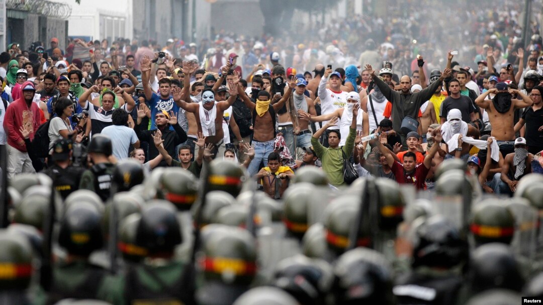 Para pendukung tokoh oposisi Henrique Capriles berhadap-hadapan dengan polisi anti huru-hara di Caracas (15/4). Ratusan pendukung oposisi bentrok dengan petugas keamanan Senin 16/4. 