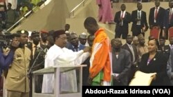 Le président Issoufou Mahamadou décorant le taekwondoïste de l'Ordre national du Niger, le 25 août 2016. (VOA/Abdoul-Razak Idrissa)