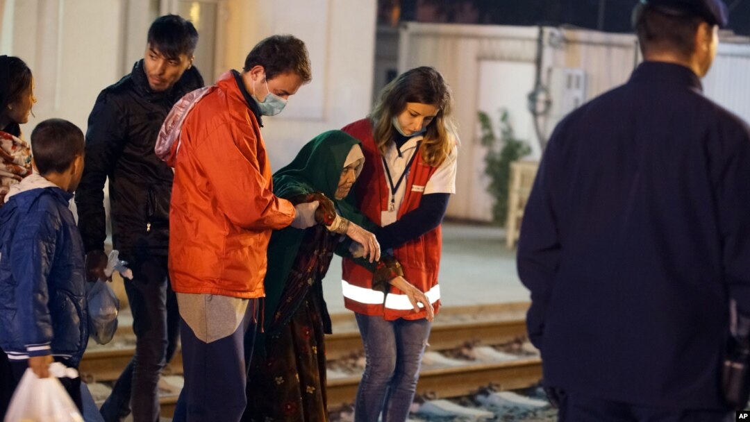 Arhiva - Volonteri pomažu avganistanskoj izbeglici Bibihal Uzbeki iz Kuduza, Avganistan, u glavnom izbegličkom kampu u Opatovcu, u Hrvatskoj, blizu granice sa Srbijom, 27. oktobra 2015. 