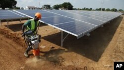 In this photo taken June 30, 2016, a Ugandan worker levels the ground at a solar plant in Soroti about 300 kilometers east of Uganda capital Kampala.