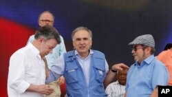 Jean Arnault, perwakilan PBB untuk proses perdamaian Kolombia (tengah), berbicara dengan Presiden Kolombia Juan Manuel Santos (kiri) dan Rodrigo Londono, yang juga dikenal sebagai Timoleon Jimenez (Timochenko), komandan tertinggi Angkatan Bersenjata Revolusioner Kolombia (FARC), dalam proses pelucutan senjata pemberontak FARC, di Buenavista, Kolumbia, Selasa, 27 Juni 2017. (Foto: dok).