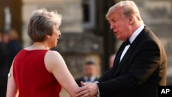 Britain's Prime Minister Theresa May welcomes President Donald Trump ahead of a black-tie dinner at Blenheim Palace in London, July 12, 2018. 