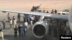 Airport officials negotiate with members of al-Awfea militia on the tarmac of Tripoli international airport in this still image taken from video June 4, 2012.